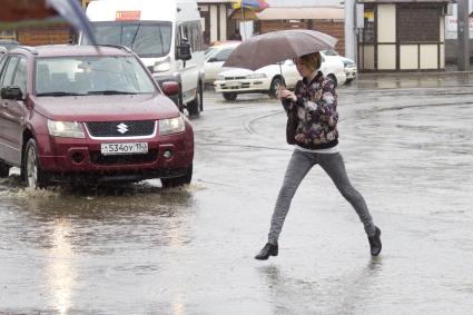 Иркутск. Женщина переходит дорогу во время дождя.