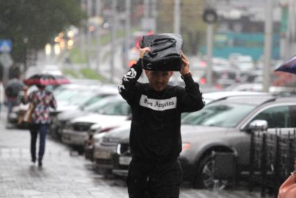 Иркутск.  Мужчина во время дождя на одной из улиц города.