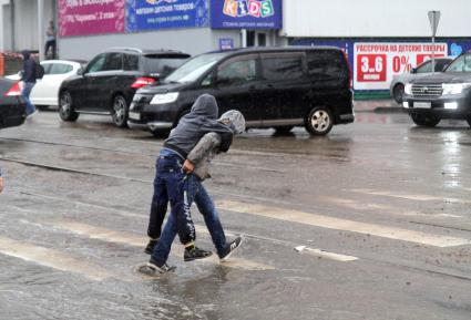 Иркутск. Дети идут по пешеходному переходу во время дождя.