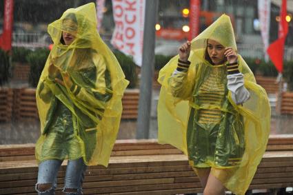 Москва. Девушки в дождевиках  во время дождя на Новом Арбате.