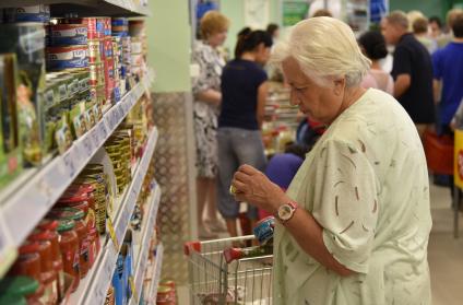 Новосибирск.  Пенсионерка  изучает ассортимент в продуктовом магазине.