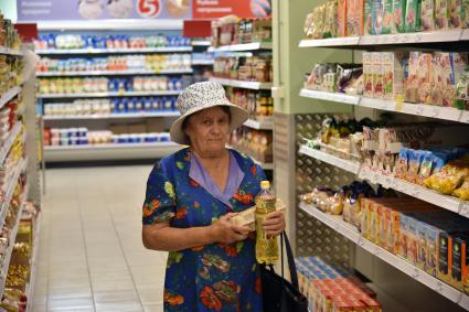 Новосибирск.  Пенсионерка  делает покупки в продуктовом магазине.