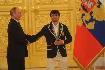 Москва. Президент РФ Владимир Путин и олимпийский чемпион по дзюдо Беслан Мудранов (справа) на церемонии вручения государственных наград победителям и призерам Олимпийских игр 2016 в Рио-де-Жанейро в Большом Кремлевском дворце.