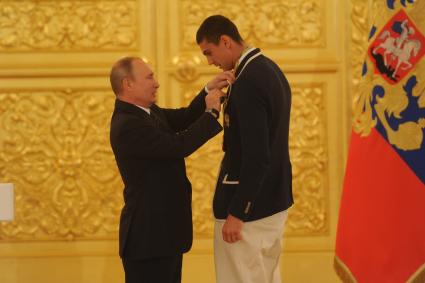 Москва. Президент РФ Владимир Путин и олимпийский чемпион по боксу Евгений Тищенко (справа) на церемонии вручения государственных наград победителям и призерам Олимпийских игр 2016 в Рио-де-Жанейро в Большом Кремлевском дворце.