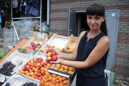 Нижний Новгород. Девушка выбирает фрукты на рынке .