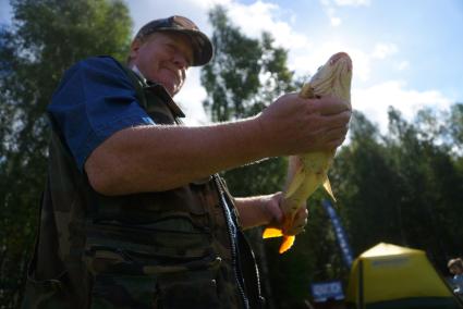 Екатеринбург. Мужчина с пойманной рыбой (карп) на фестивале семейной рыбалки