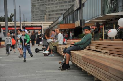 Москва.  Люди отдыхают на скамейке  на улице Новый Арбат после его реконструкции.