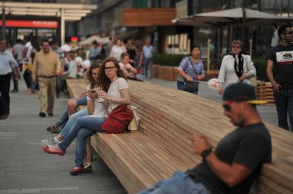 Москва. Девушки отдыхают на скамейке на улице Новый Арбат после его реконструкции.