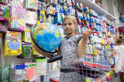 Челябинск. Девочка выбирает глобус в отделе школьных товаров.