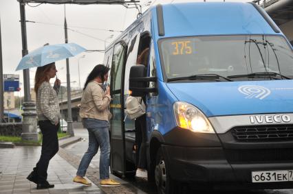 Москва. Пассажиры садятся в маршрутное такси на одной из улиц города.