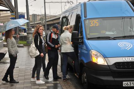 Москва. Пассажиры садятся в маршрутное такси на одной из улиц города.