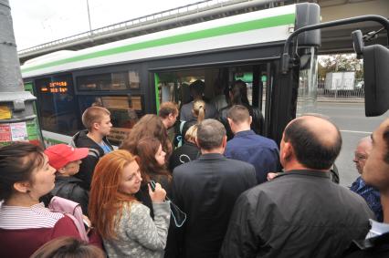 Москва.  Пассажиры садятся в автобус.