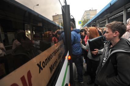 Москва.  Пассажиры садятся в автобус.