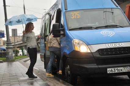 Москва. Пассажиры садятся в маршрутное такси на одной из улиц города.