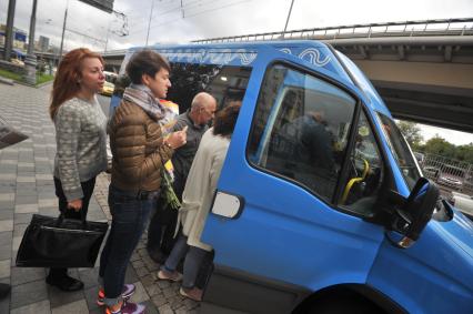 Москва. Пассажиры садятся в маршрутное такси на одной из улиц города.