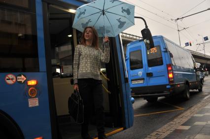 Москва. Девушка выходит из автобуса на одной из улиц города.