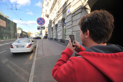 Москва. Корреспондент газеты `Комсомольская правда` Олег Адамович тестирует мобильное приложение `Помощник Москвы`, выписывающее штрафы за неправильную стоянку.