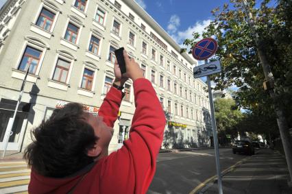 Москва.  Корреспондент газеты `Комсомольская правда` Олег Адамович  тестирует мобильное приложение `Помощник Москвы`, выписывающее штрафы за неправильную стоянку.