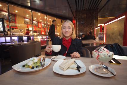 Москва. Девушка за столиком в первой кофейне при московском метро `М Кафе` на станции `Выставочная` .