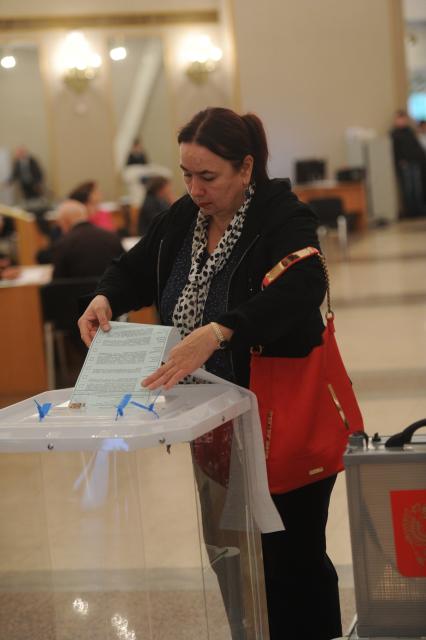 Москва.   Жительница города в единый день голосования на избирательном участке # 2151 в Российской академии наук (РАН).