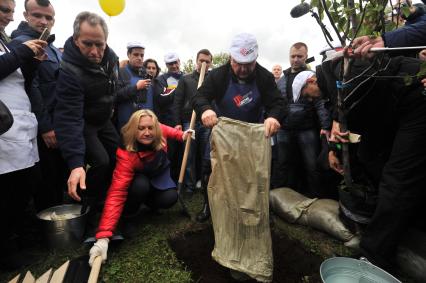 Москва. Бывший мэр Москвы Юрий Лужков (в центре) с супругой Еленой Батуриной во время посадки фруктового дерева на субботнике в честь его 80-летия  в музее-заповеднике `Коломенское`.