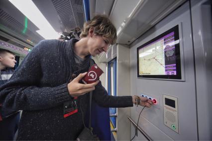 Москва. Во время презентации инновационного подвижного состава для метрополитена 765-й серии `Москва` на выставочной площадке ВДНХ. Молодой человек заряжает мобильный телефон.