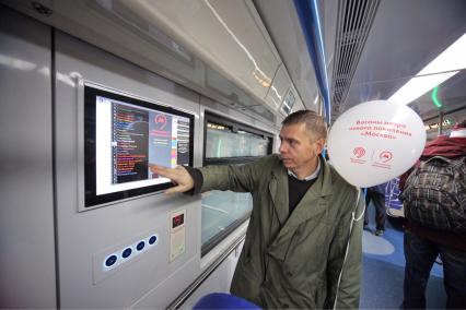 Москва. Презентация инновационного подвижного состава для метрополитена 765-й серии `Москва` на выставочной площадке ВДНХ. Мужчина у информационного табло.