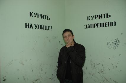 Екатеринбург. Парень курит под надписью \'Курить на улице!\' \'Курить запрещено\'