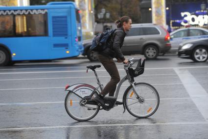 Москва.  Молодой человек едет на велосипеде по Тверской улице.