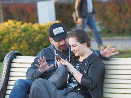 Москва. Молодой человек и девушка сидят на скамейке.