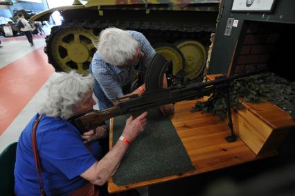 Англия. Лондон.  Посетители стреляют в небольших тирах, которые установленны в залах музея  танков в Бовингтоне.