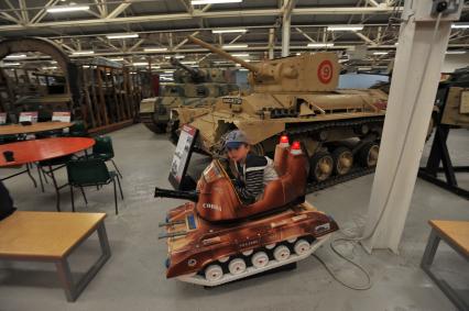 Англия. Лондон.  Мальчик играет с макетом танка cobra  в одном из залов  музея танков в Бовингтоне.