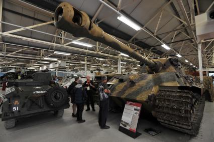 Англия. Лондон. Экскурсовод  проводит экскурсию в одном из залов музея  танков в Бовингтоне.