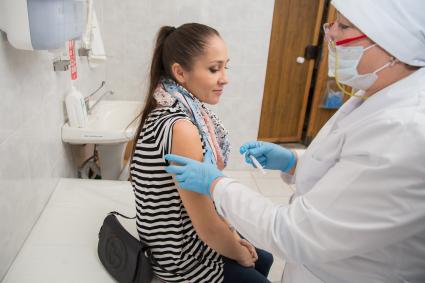 Челябинск. Девушка  в поликлиннике делает прививку от гриппа.