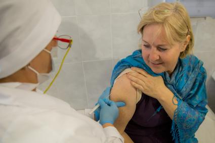 Челябинск. Женщина  в поликлиннике делает прививку от гриппа.