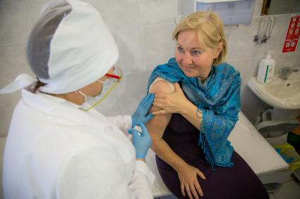 Челябинск. Женщина  в поликлиннике делает прививку от гриппа.