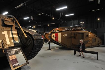 Англия. Лондон. Посетительница в зале среди танков MARK IX  времен  Первой Мировой войны в музее танков в Бовингтоне.