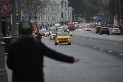 Москва. Женщина ловит такси  на улице Воздвиженка.