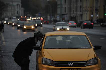 Москва. Женщина разговаривает с таксистом на улице Воздвиженка.