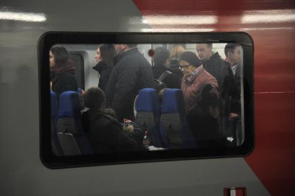 Москва. Пассажиры в вагоне поезда на Московском центральном кольце (МЦК).