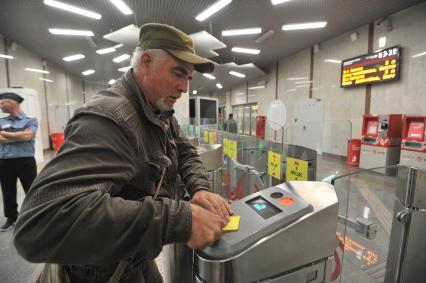 Москва. Пассажир прикладывает проездной билет к турникету на одной из станций  Московского центрального кольца (МЦК).