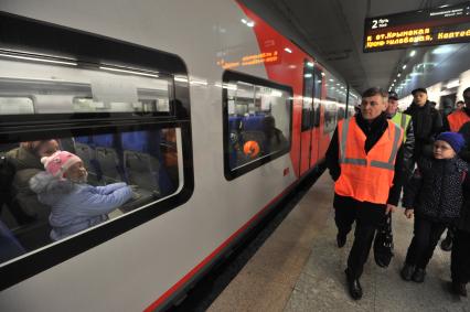 Москва.  Пассажиры в  вагоне поезда `Ласточка` на станции Московского центрального кольца (МЦК).