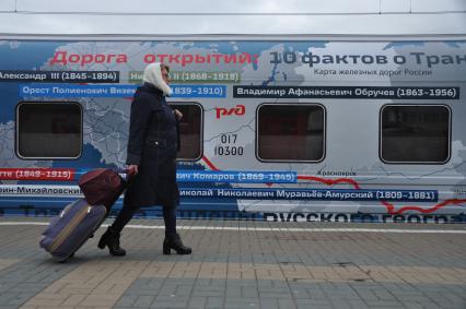 Москва. Пассажирка  рядом с юбилейным фирменным поездом `100 лет Трансибу` перед его отправлением во Владивосток с Ярославского вокзала.