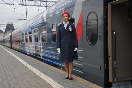 Москва. Проводница рядом с  вагоном юбилейного фирменного поезда  `100 лет Трансибу` перед отправлением его во Владивосток с Ярославского вокзала.