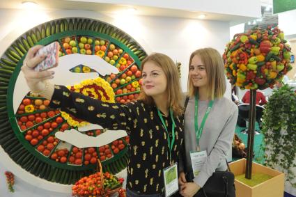 Москва. Девушки фотографируются рядом с декоративным панно на 18-й агропромышленной выставке `Золотая осень` на территории ВДНХ.