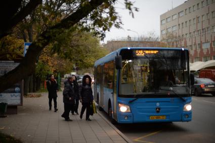 Москва. Пассажиры садятся в автобус на остановке общественного транспорта`Старый Петровско-Разумовский проезд`.