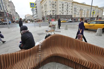 Москва.  Девушка отдыхает на скамейке на Тверской улице после ее реконструкции.