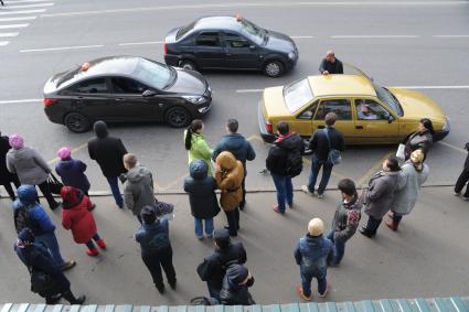 Москва.   Пассажиры на остановке общественного транспорта.