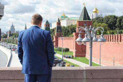 Москва. Мужчина смотрит на Кремль с Большого Москворецкого моста. Постановочный кадр.