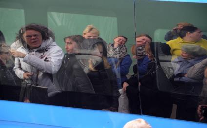 Москва.  Пассажиры отражаются в окне  маршрутного такси.